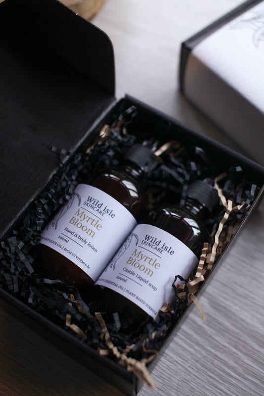 Two bottles of 'Myrtle Bloom' soap and lotion set in a black gift box.